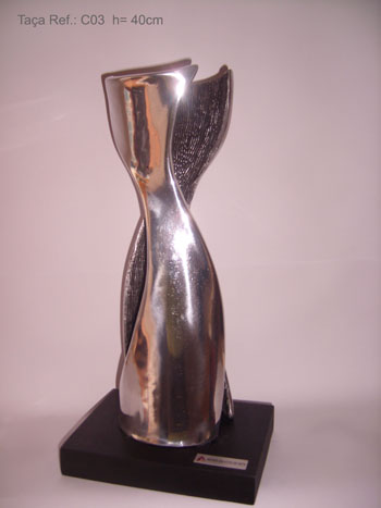 Troféu em fundição de alumínio com textura, base de madeira. Altura: 40 cm.